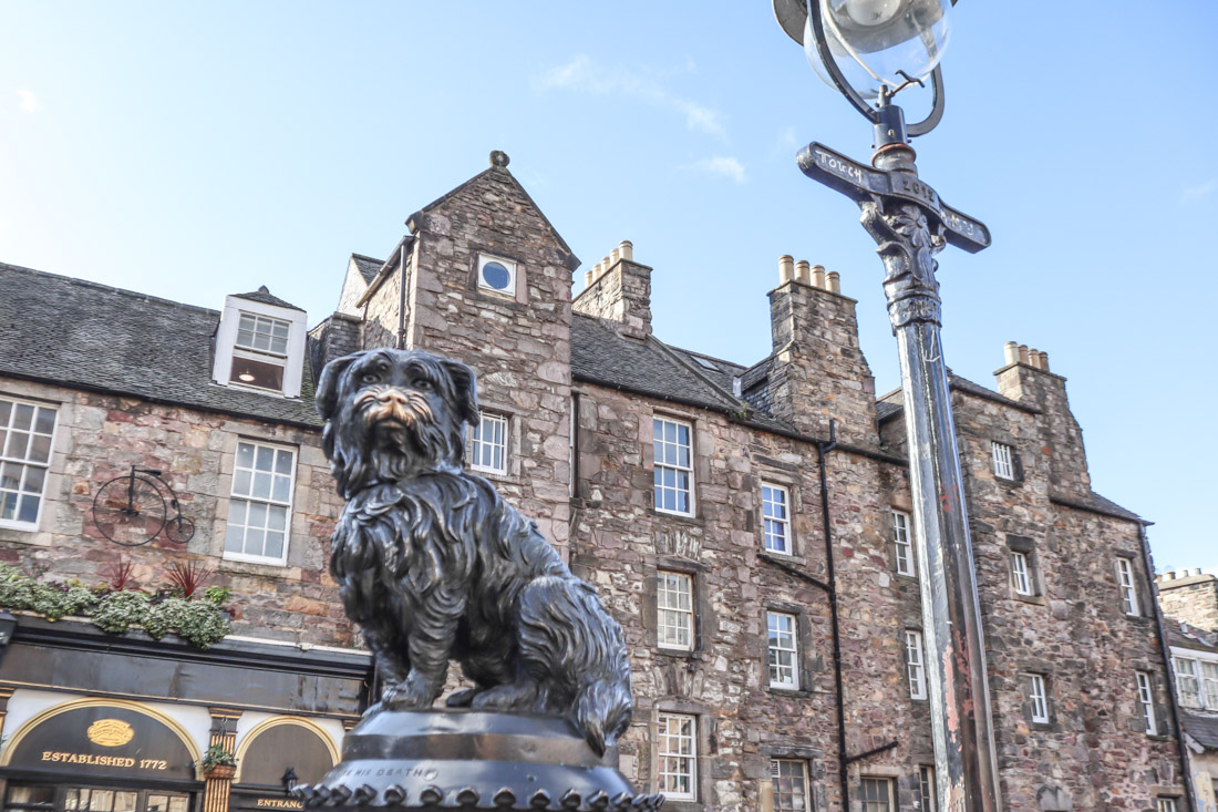 Greyfriars Bobby statue of dog in Edinburgh in front of old buildings