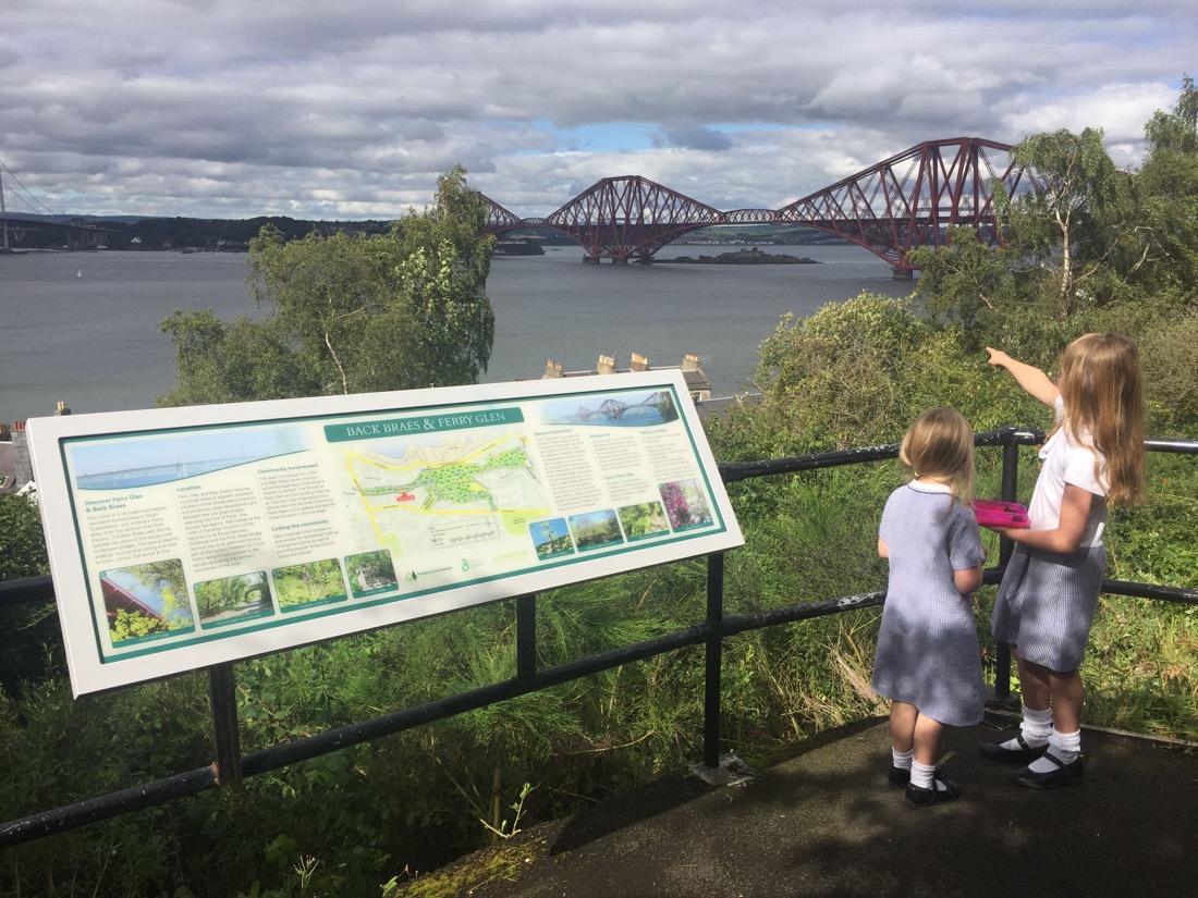 Two young girls pointing at Forth Rail Bridge South Queensferry
