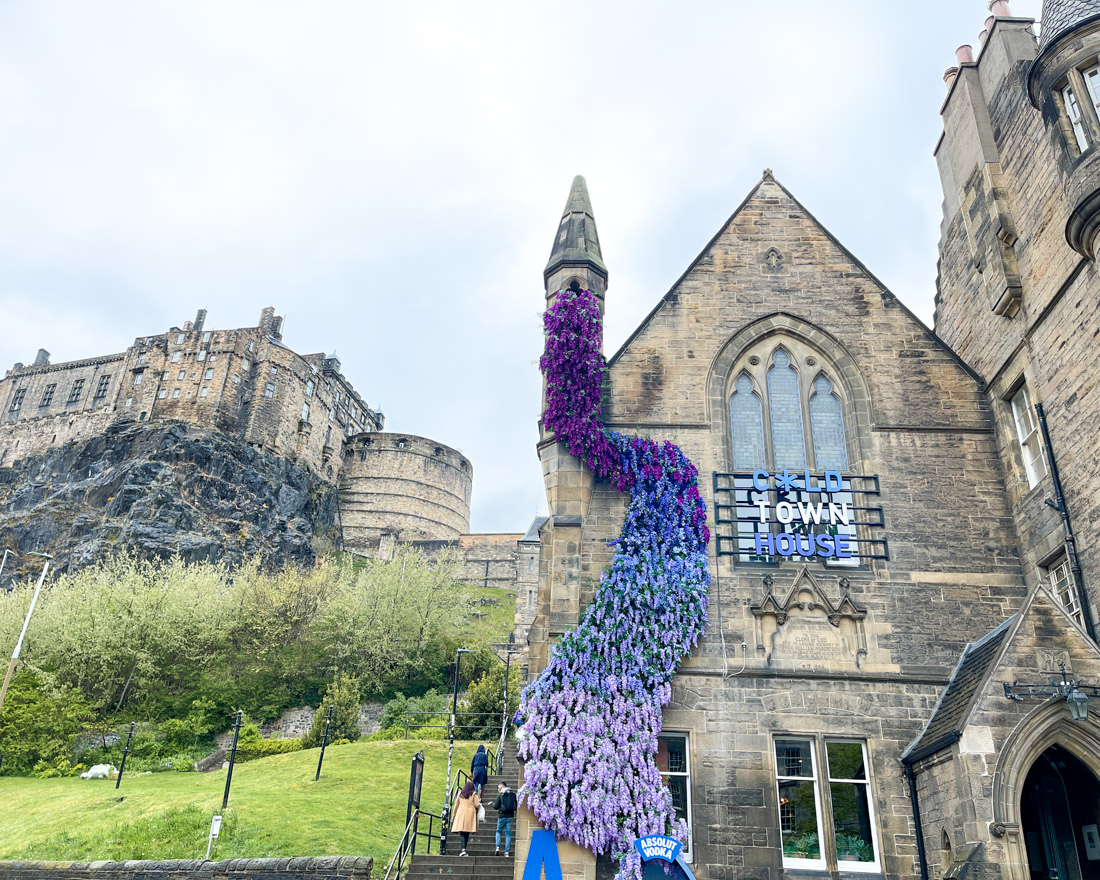 Cold Town House purple flower display on building and Edinburgh Castle on Castlehill
