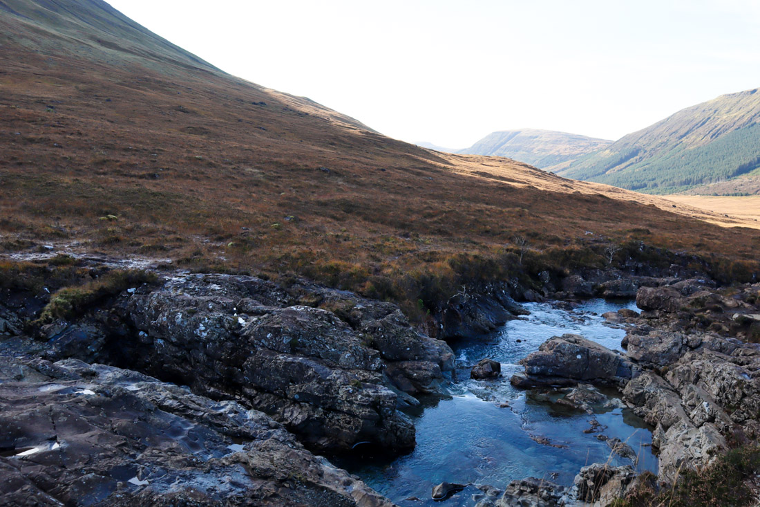 Fairy Pools in Skye sitting in shadow of mountain in Scotland