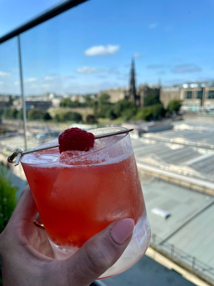 Nor Loft rooftop bar cocktail cheersing Edinburgh skyline