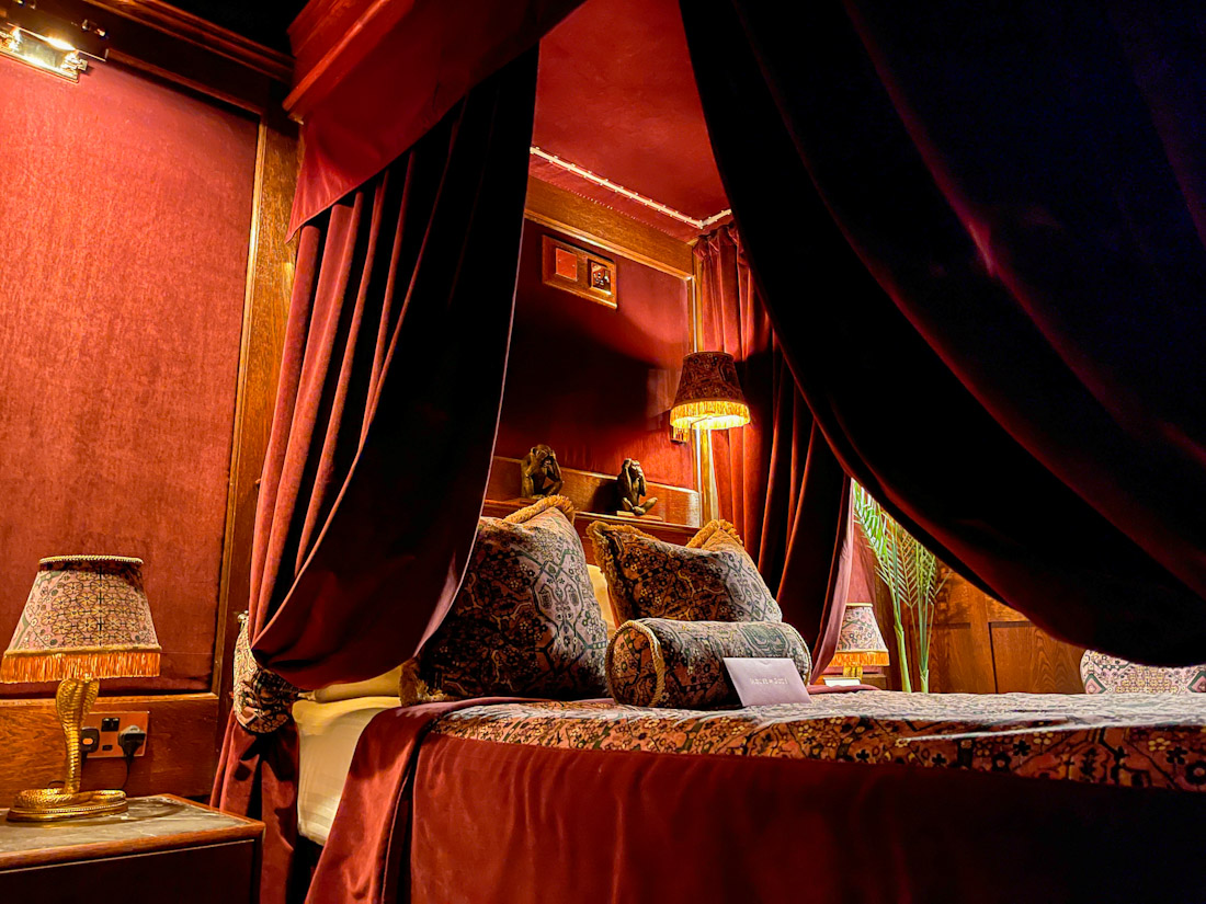 House of Gods Hotel four post bed with red drapes