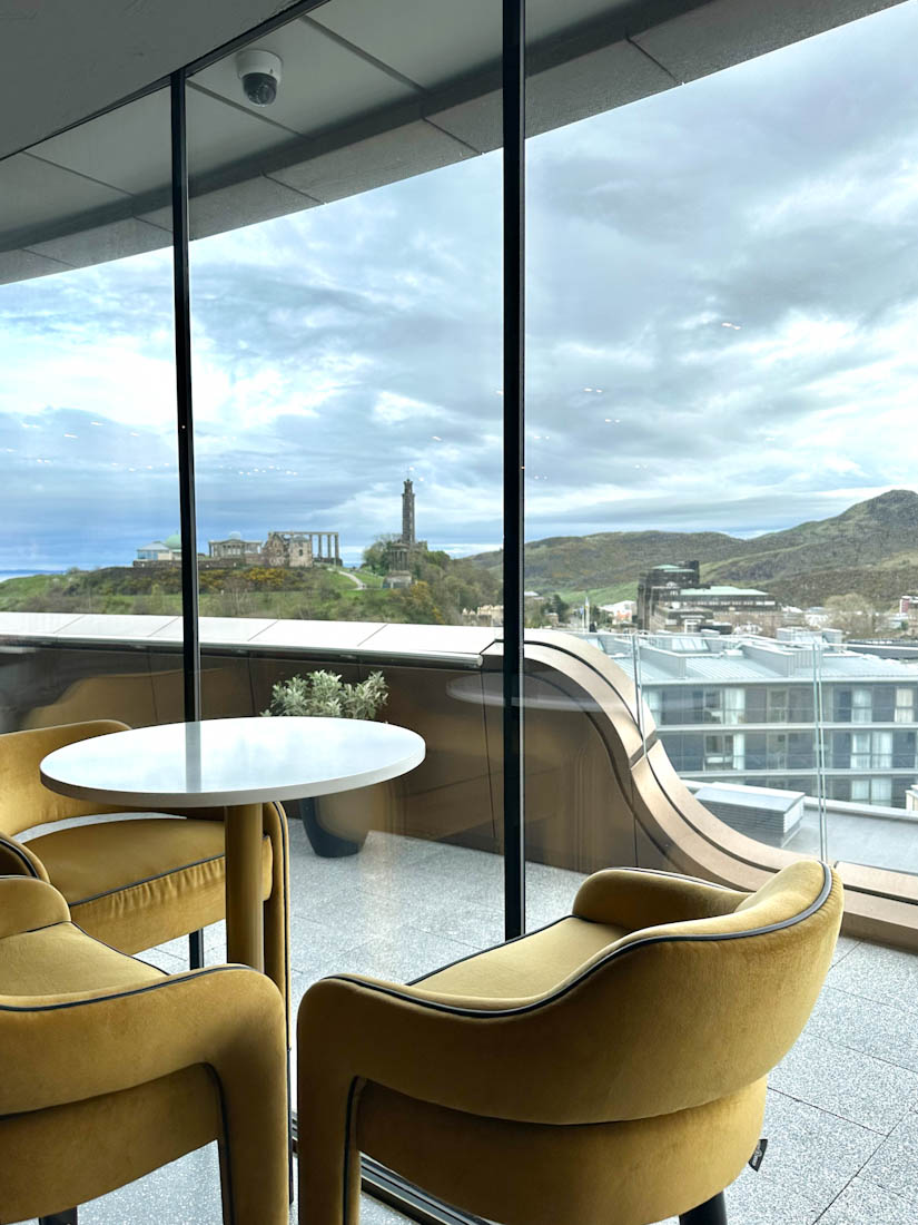 W Hotel Lounge in front of glass window with Edinburgh skyline 