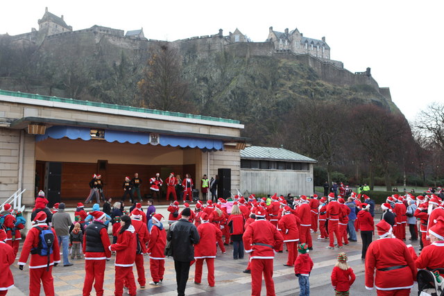 Runners in Santa suits warming up below the castle before the fun run